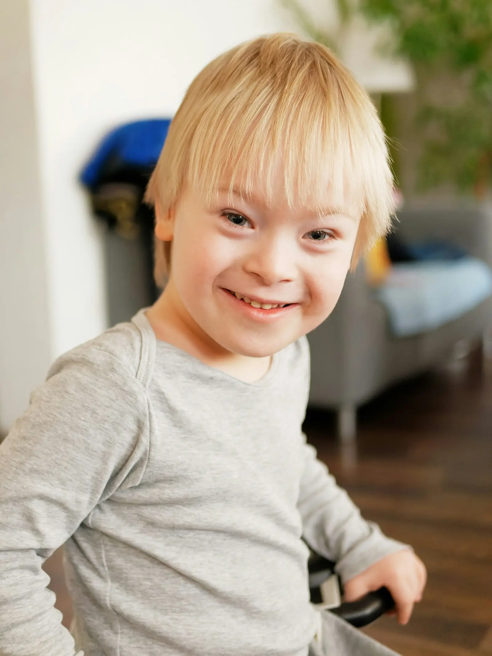 Menino com síndrome de Down sorrindo em casa